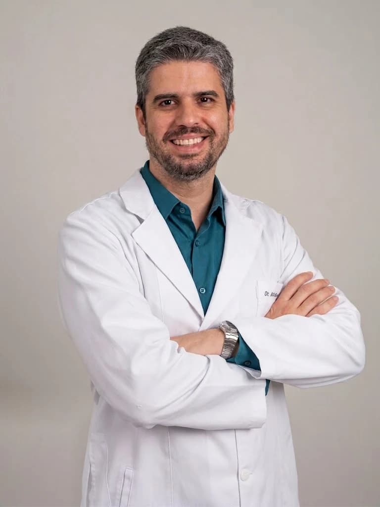Dr. André Gobatto, médico intensivista, de jaleco branco e sorrindo